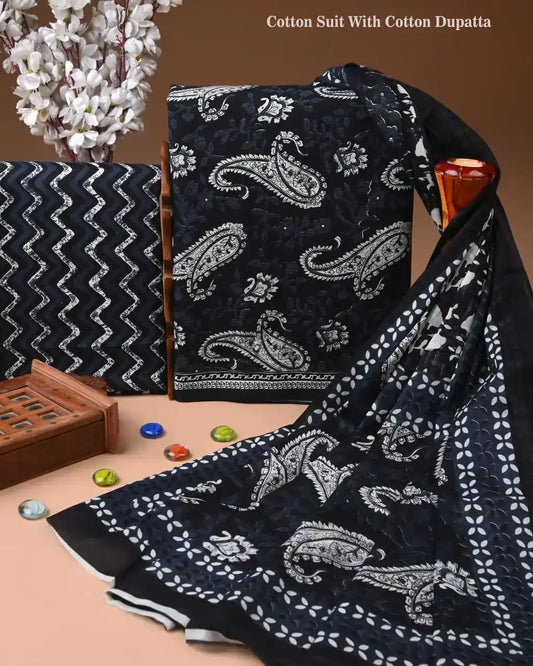 Black cotton suit with white paisley pattern and matching dupatta on a brown background.