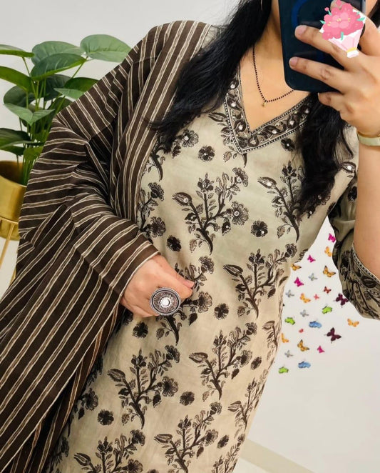 Person wearing a floral dress with a striped shawl, holding a phone with a colorful case.