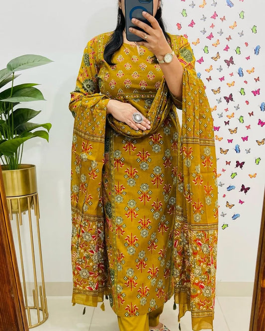 Person wearing a yellow floral outfit standing in front of a decorative wall with butterflies.