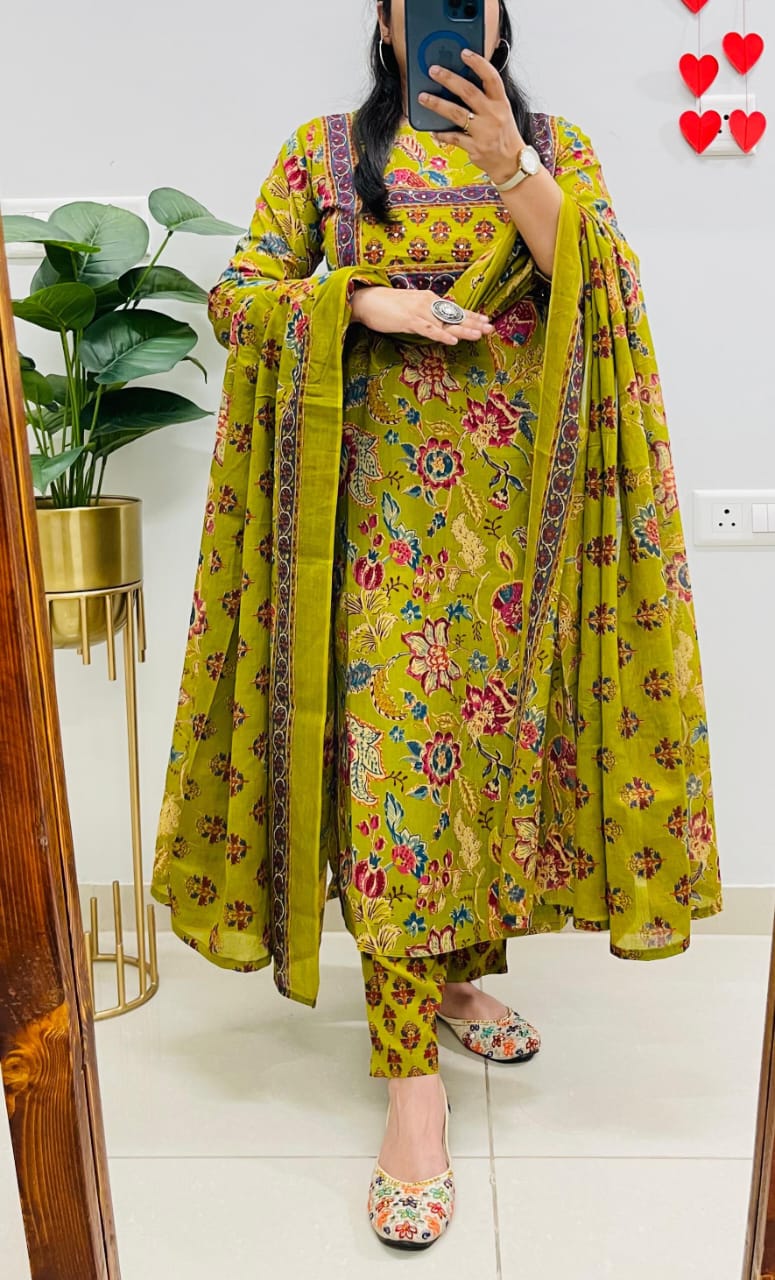 Person wearing a yellow floral dress with a matching dupatta in a room.