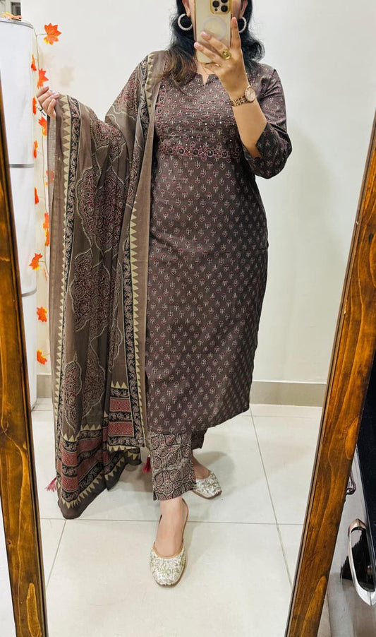 Woman taking a mirror selfie wearing a patterned dress with a long scarf.