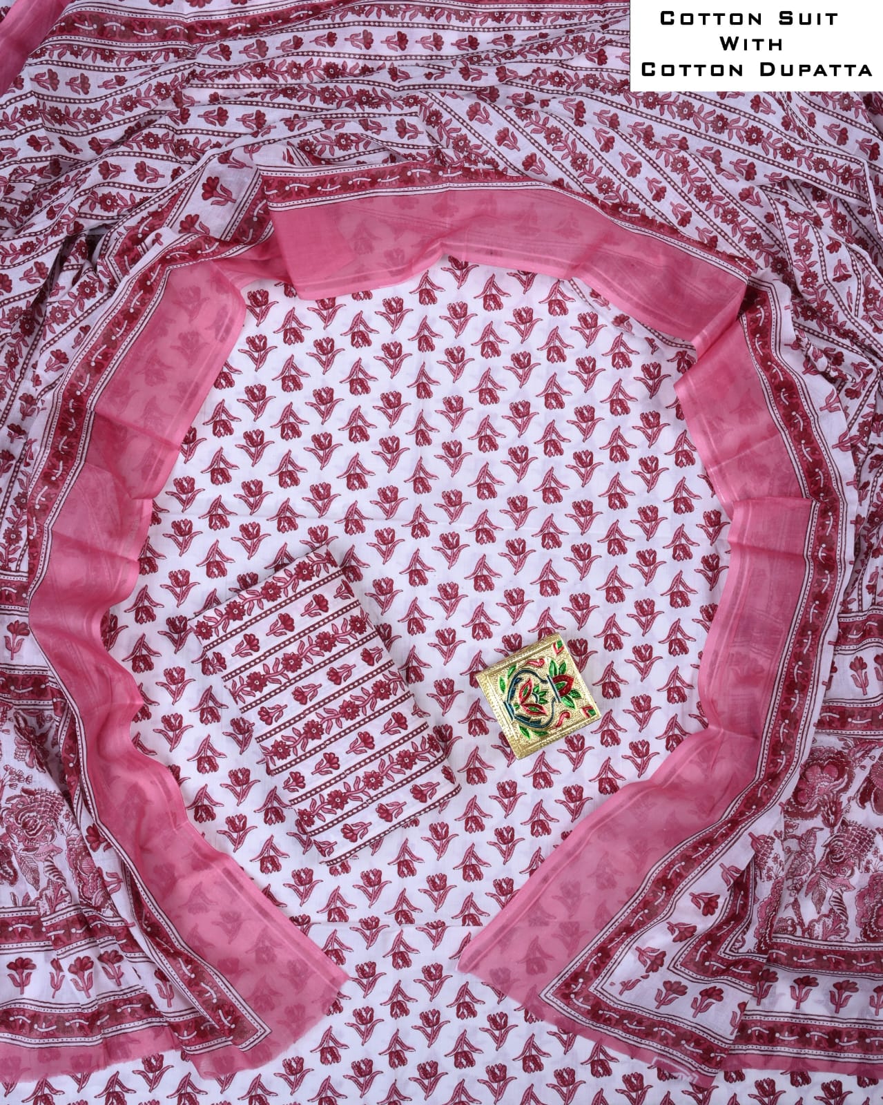 Cotton suit with a pink dupatta featuring intricate patterns on a white background.